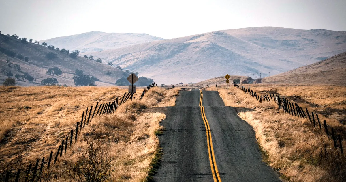 Two-lane road running through golden hills in Central California