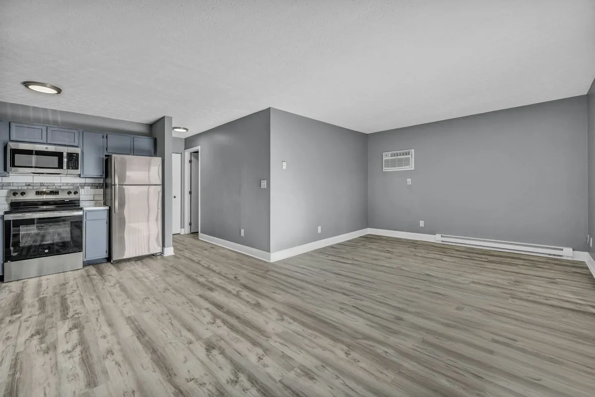 Empty apartment kitchen with blue cabinets and stainless appliances