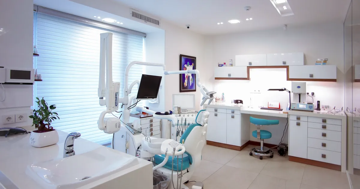 Empty modern dental treatment room with a dental chair and equipment