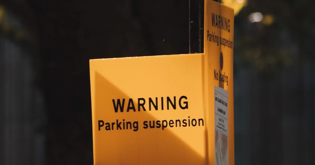 Temporary no-parking tow-away sign posted at the curb on a city street