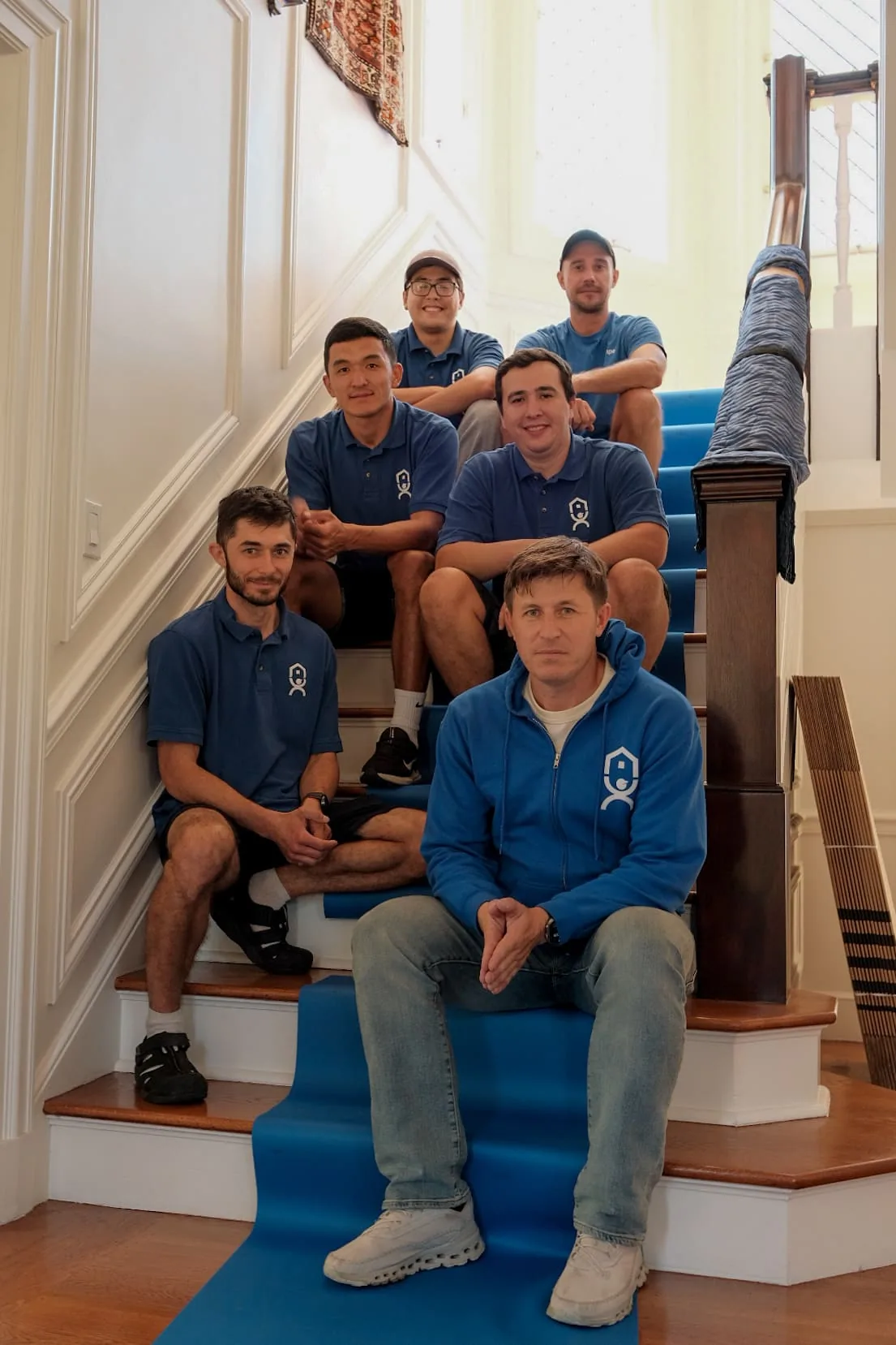 Movers carrying a wrapped item down an exterior stairway